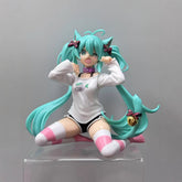 The Kneeling Cat-Ear Hatsune Miku 11cm PVC Figure features teal hair, cat ears, a white long-sleeve shirt, striped pink and white socks, black shorts, and a clear platform. This cute & playful collectible by Hatsune Miku showcases an energetic expression ideal for anime figure collectors.