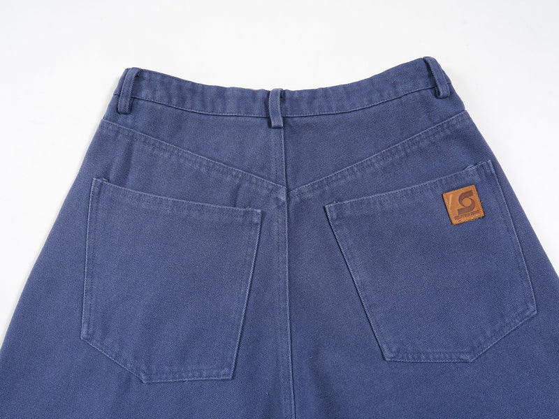 Blue jorts back waist close-up with patch pockets and brown logo label on the right pocket