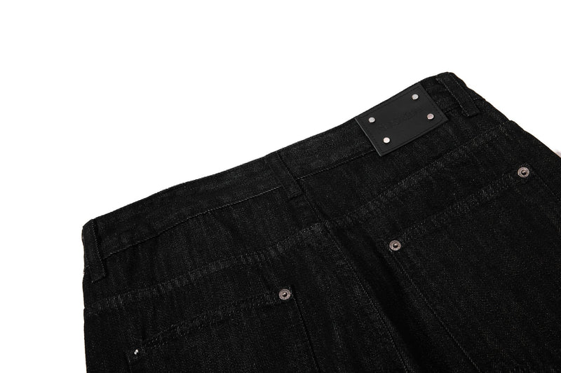 Close-up of back waistband and black patch on black denim pants