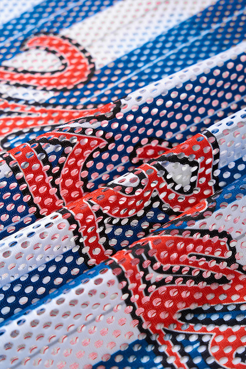 Close-up of a blue, white and red mesh jersey fabric with bold varsity-style lettering and perforated texture