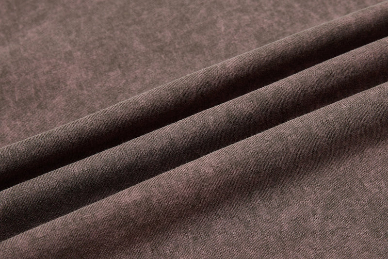 Close-up of brown washed raglan tee fabric with soft vintage texture and folded sleeve details