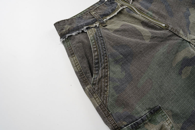 Close-up of the front side seam and pocket opening on camouflage cargo shorts