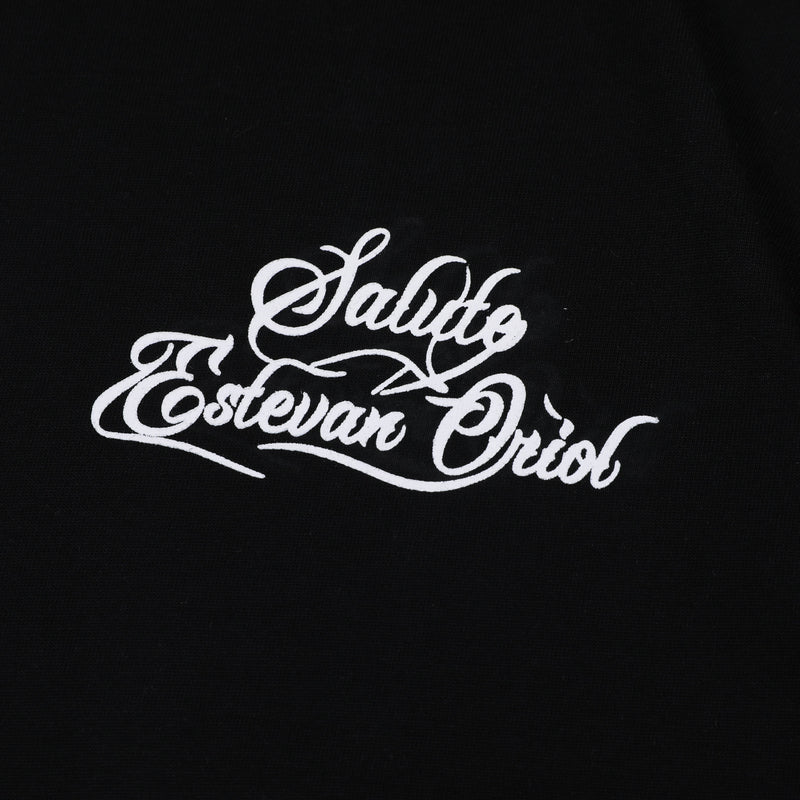 Black oversized tee with white Saludo Estevan Oriol script graphic on the front