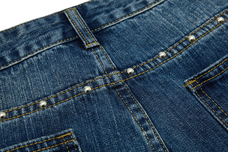 Close-up of blue denim back waistband with studs and center belt loop