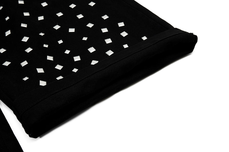 Close-up of black pant cuff with silver square studs