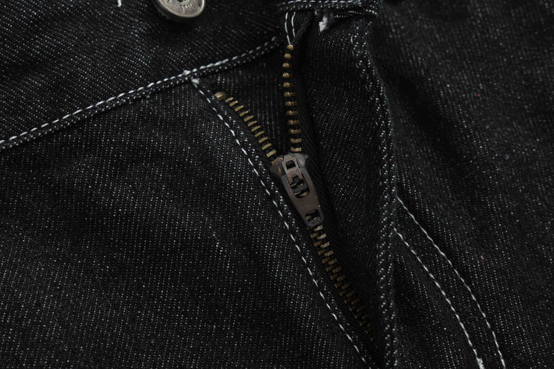 Extreme close-up of black denim zipper fly and seam stitching