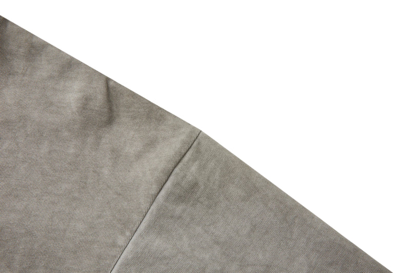 Close-up of a vintage washed heavyweight cotton tee in muted beige with visible shoulder seam detail