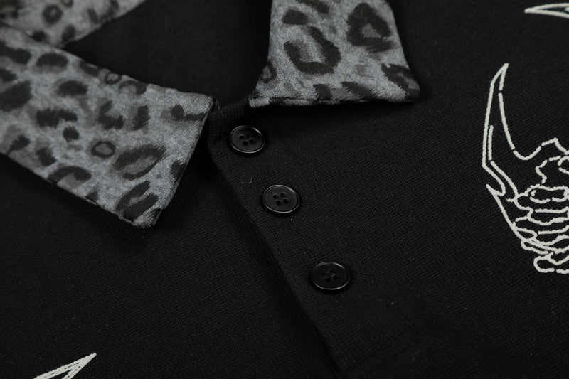 Black polo tee with leopard-print collar and cuffs, white graphic print, and three-button placket in streetwear style
