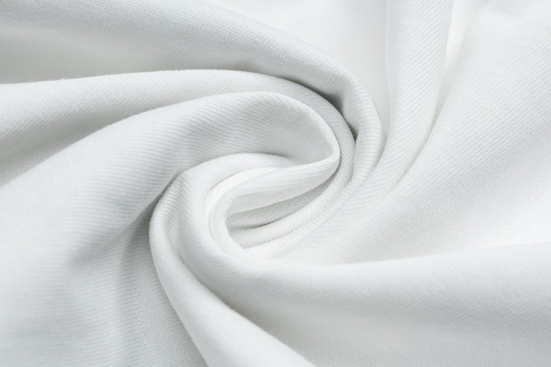 White cotton fabric close-up with soft woven texture, likely for a retro pop graphic ringer tee