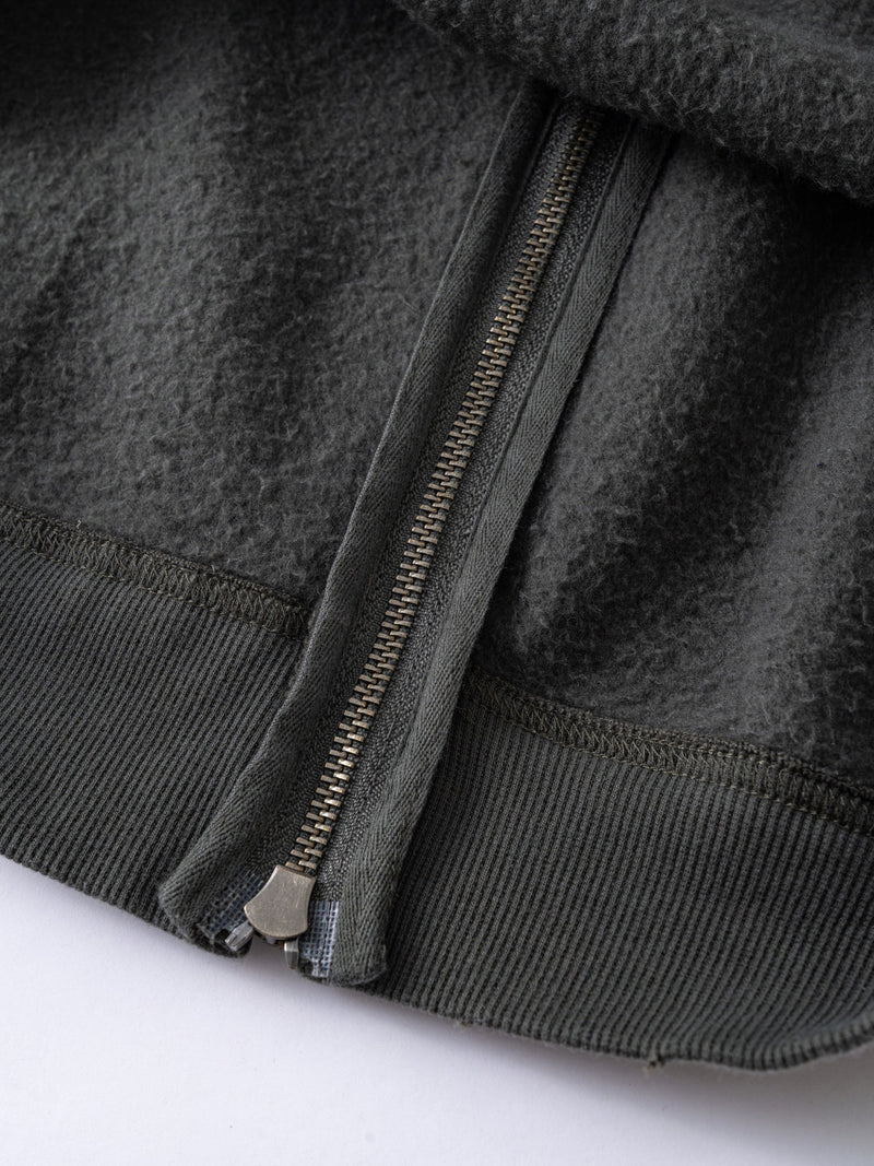 Close-up of gray hoodie zipper, fleece lining, and ribbed hem
