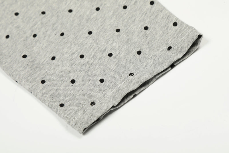 Close-up of gray polka dot sleeve hem on mixed pattern raglan tee