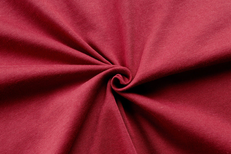 Red cotton fabric close-up with gathered folds