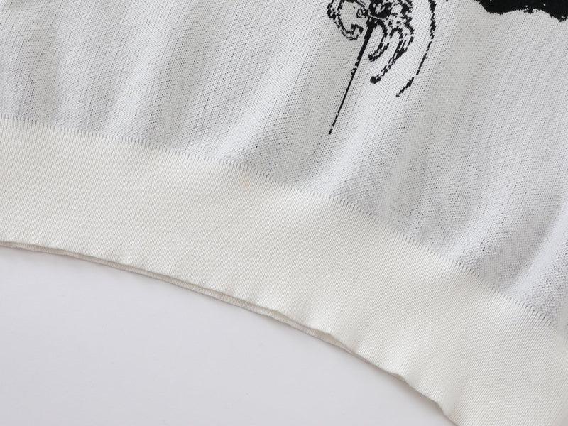Close-up of white knit sweater hem showing ribbed cuff and knit texture