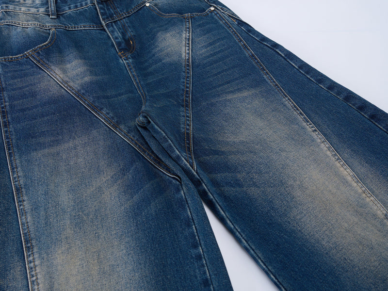 Close-up of the front upper legs on wide-leg blue jeans with V-shaped seam details