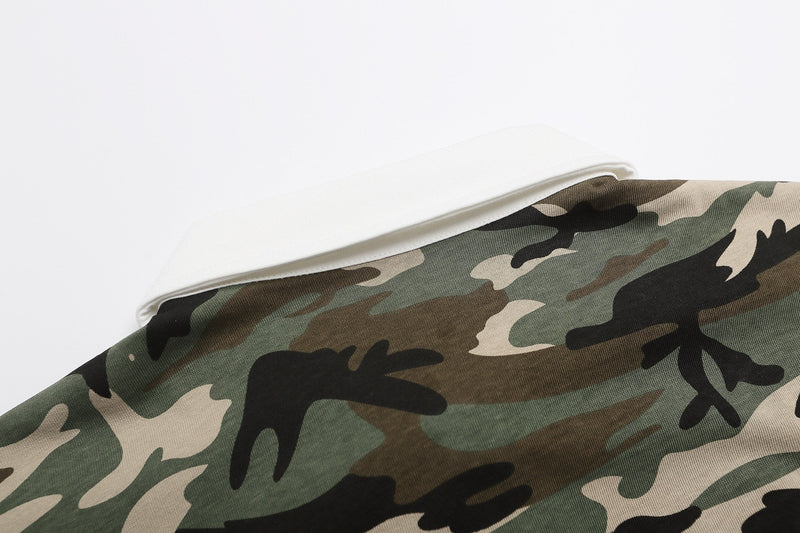 Folded camo heritage polo shirt with green, black, and beige camouflage pattern on a white background