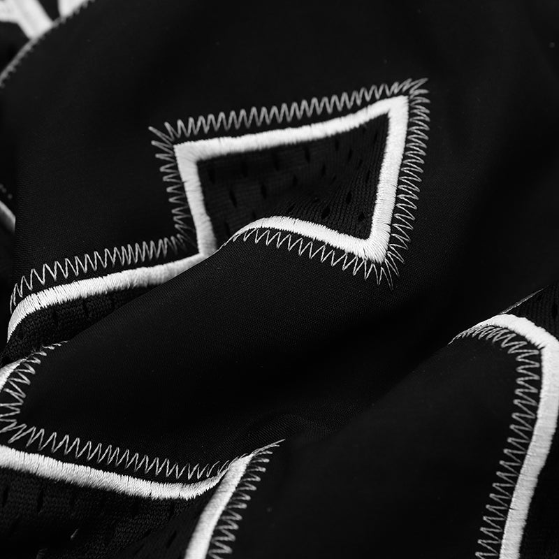 Black mesh football jersey tee with white contrast stitching and varsity number detailing in a close-up fabric texture