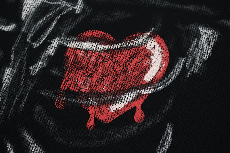 Close-up of a black graphic tee with a red melted heart and white ribcage print, edgy streetwear design