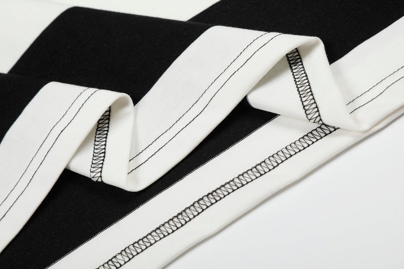 Close-up of a black and white rugby stripe polo shirt with bold panels and visible stitched seams