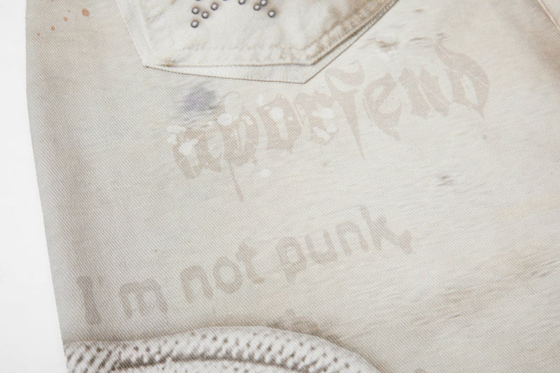 Close-up of lower leg on cream jeans with faded wash and star studs near pocket