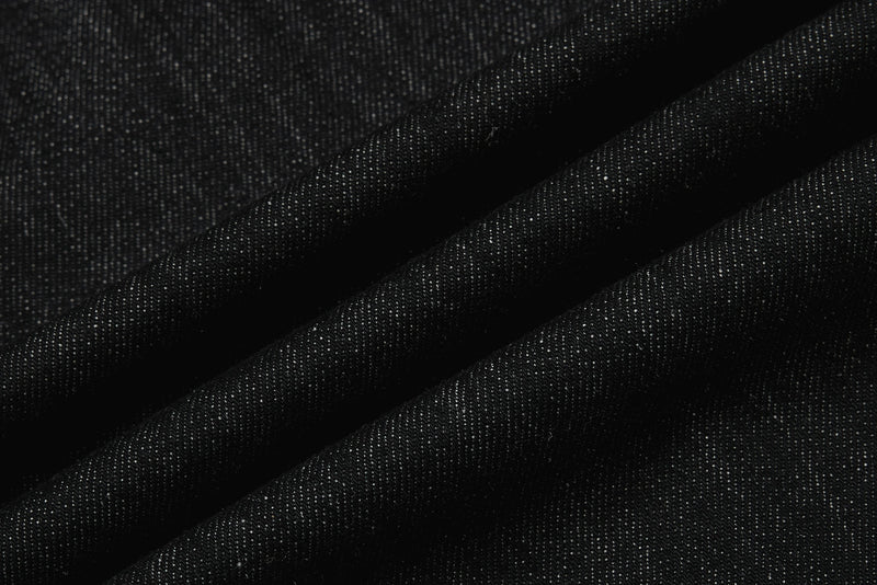 Close-up of black denim fabric texture with folded creases