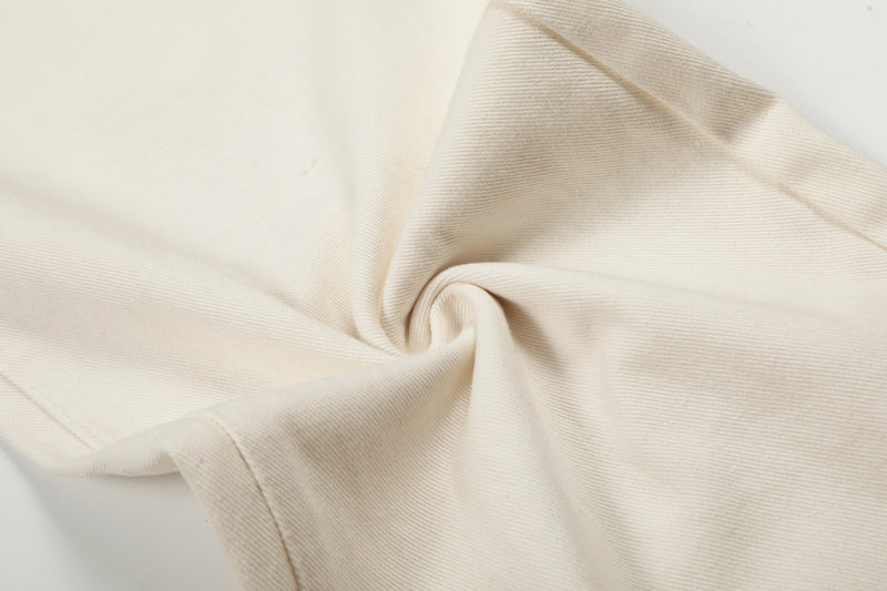 Close-up of cream denim fabric fold showing fine twill texture