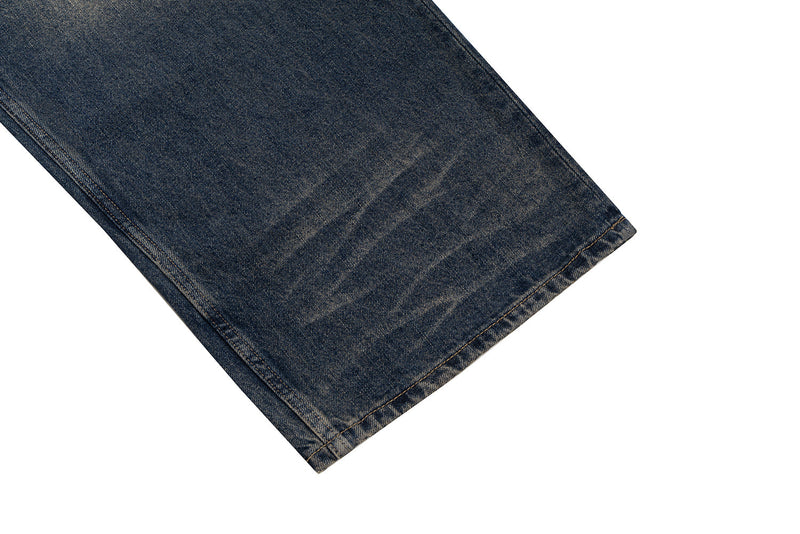 Close-up of the jean hem on dark blue denim with faded wear marks