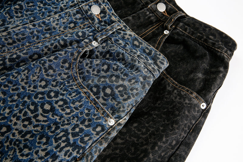 Close-up of blue and black leopard print jeans with front pocket and button details