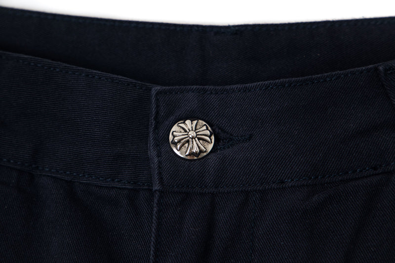 Metal button detail on black cargo pants waistband, close-up