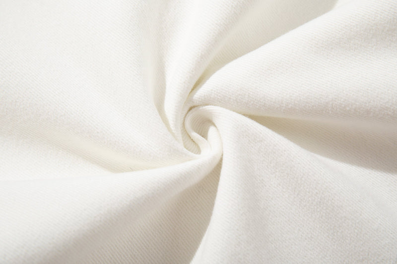 Close-up of folded white denim fabric with visible twill texture