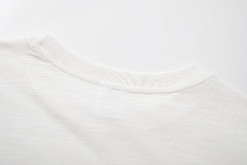 Close-up of a white cotton T-shirt collar with clean ribbed stitching and soft fabric texture
