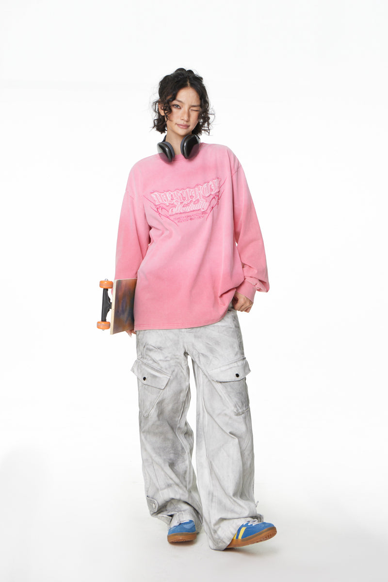 Full body view of model in pink graphic long sleeve tee holding skateboard
