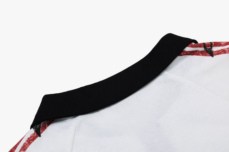 Close-up of a white men’s polo shirt with black collar and red distressed graphic print for vintage streetwear style