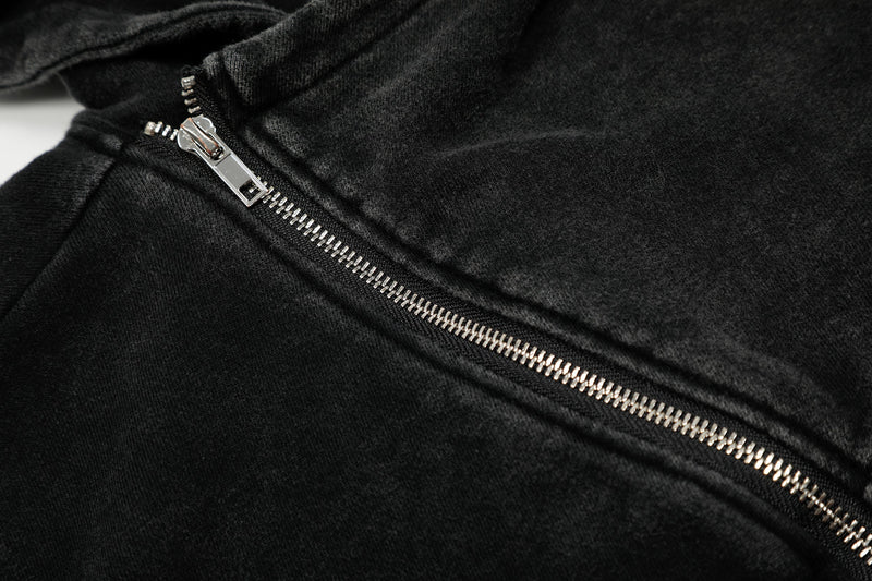 Close-up of black washed fabric with diagonal silver zipper teeth