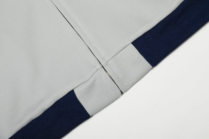 Close-up of lower hem seam with light gray body and navy ribbed trim