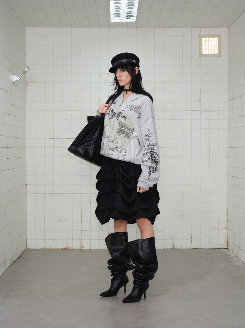 Grey doodle print zip hoodie on model, side-front view with black tote bag