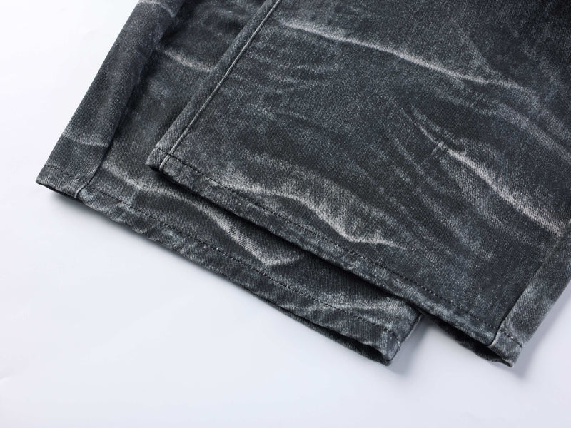 Close-up of hem on washed black wide-leg jeans with faded creased denim