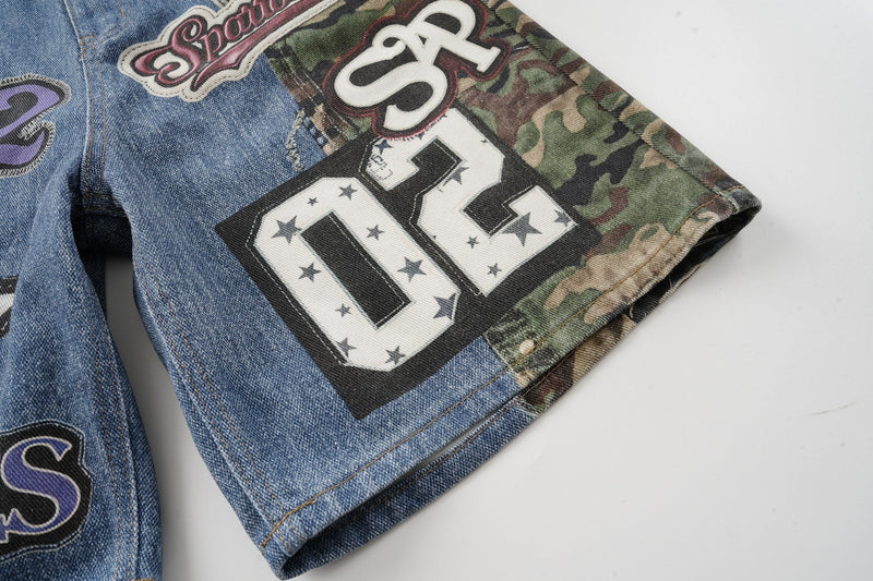 Close-up of side hem with SP2 patch on blue denim and camouflage jorts