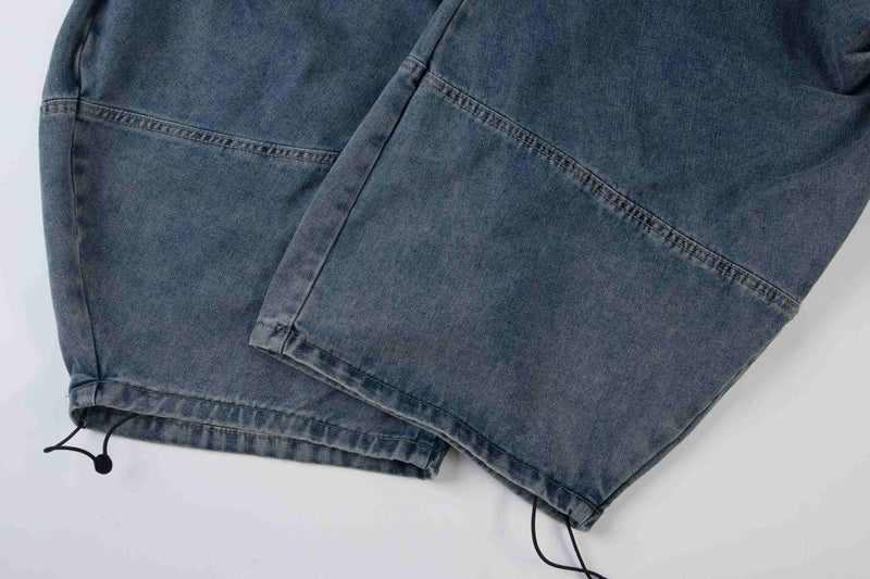 Close-up of blue denim hem with drawstring cord and stitched cuff detail