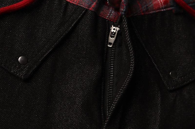 Close-up of black denim front zipper with red plaid waistband detail