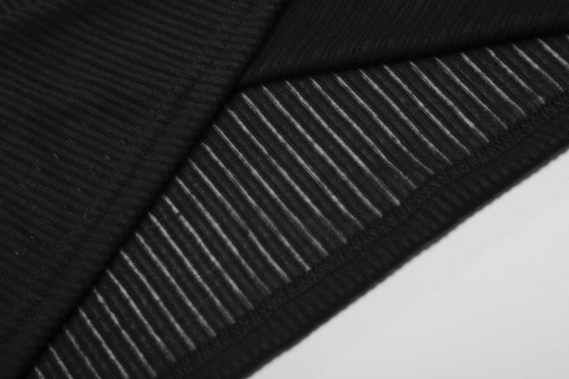 Close-up of black ribbed sleeve cuff and vertical sheer stripes
