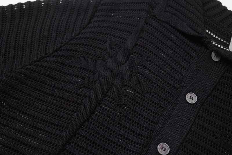 Close-up of a black open-knit short-sleeve button-up shirt with star-like textured stitching and mother-of-pearl buttons