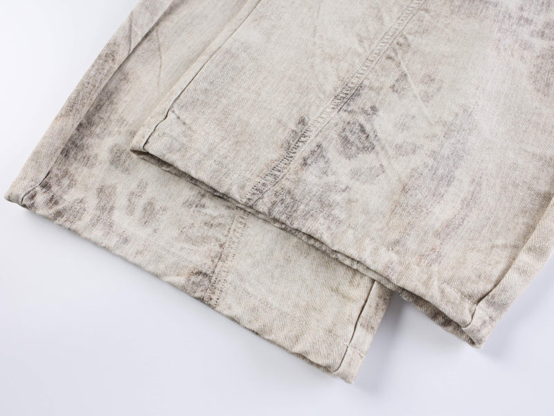 Close-up of worn hem and creased cream denim leg opening