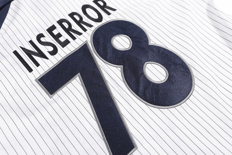 Close-up of Inserror 78 graphic on white pinstripe shirt front