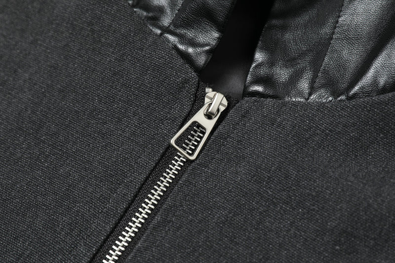 Close-up of silver front zipper on black jacket with textured woven fabric and faux leather hood