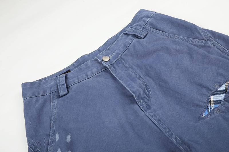 Close-up angled view of blue cargo shorts waistband and front button placket