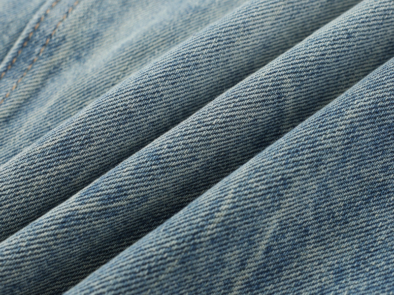 Close-up of denim fabric texture with soft diagonal folds
