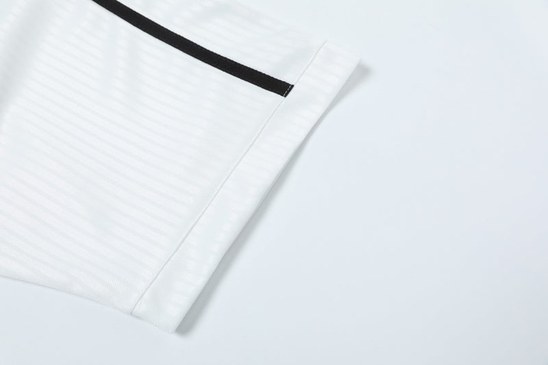 White sports jersey sleeve with black trim and textured mesh fabric detail