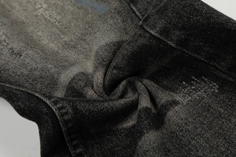 Close-up of twisted black denim fabric showing faded wash and distressed texture