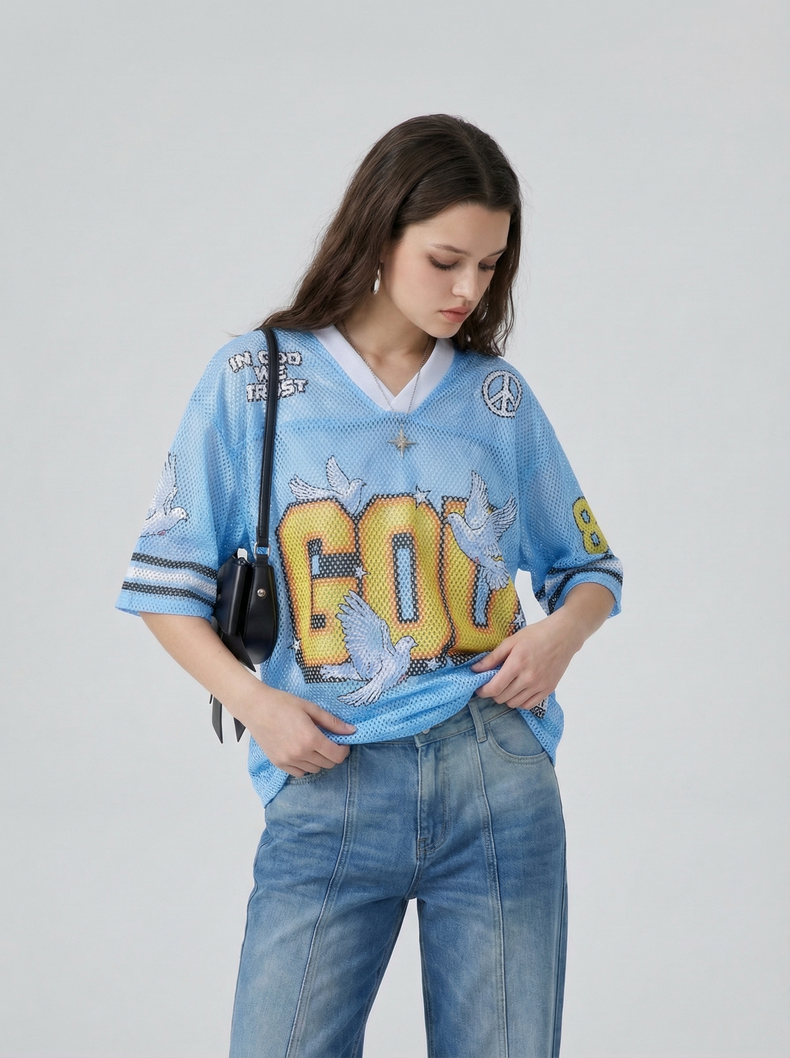 Woman wearing a blue mesh jersey T-shirt with bold GOW graphic, dove details, and relaxed streetwear styling