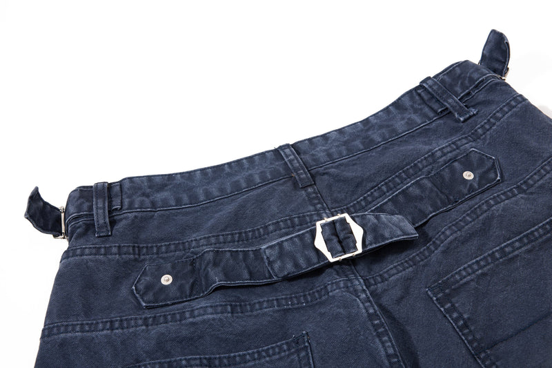 Close-up of dark wash denim shorts back waistband and side pocket detail